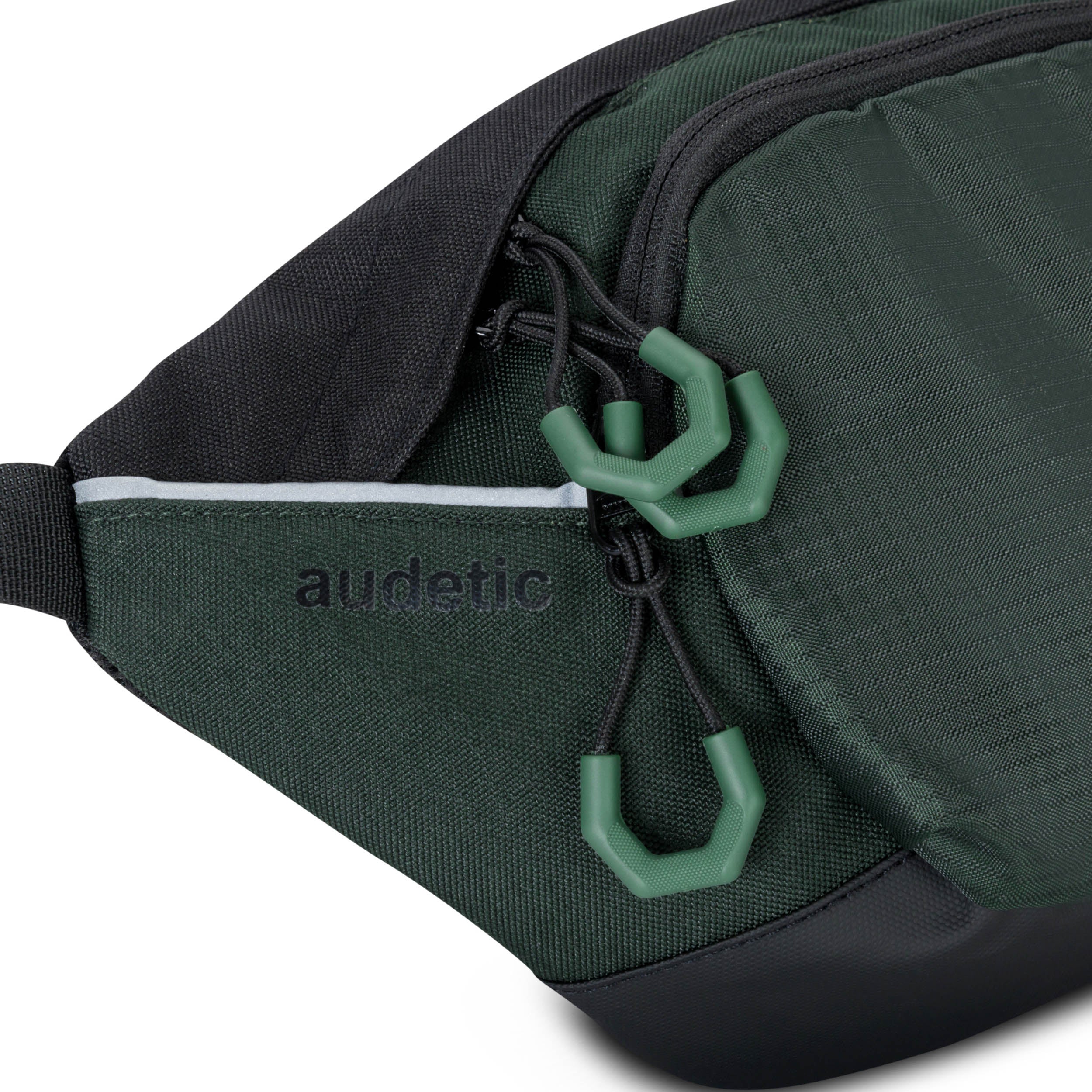 Dunkelgrüne Bauchtasche DRIP von audetic mit schwarzen Details und drei Reißverschlussanhängern