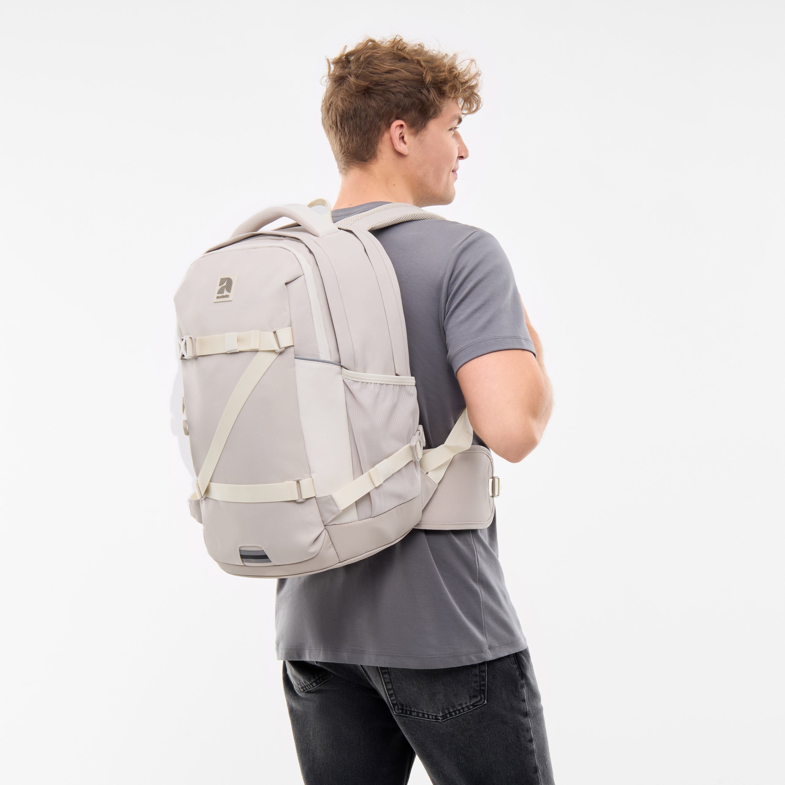 Jugendlicher trägt sandfarbenen Schulrucksack COSMO von Audetic mit Brust- und Hüftgurt