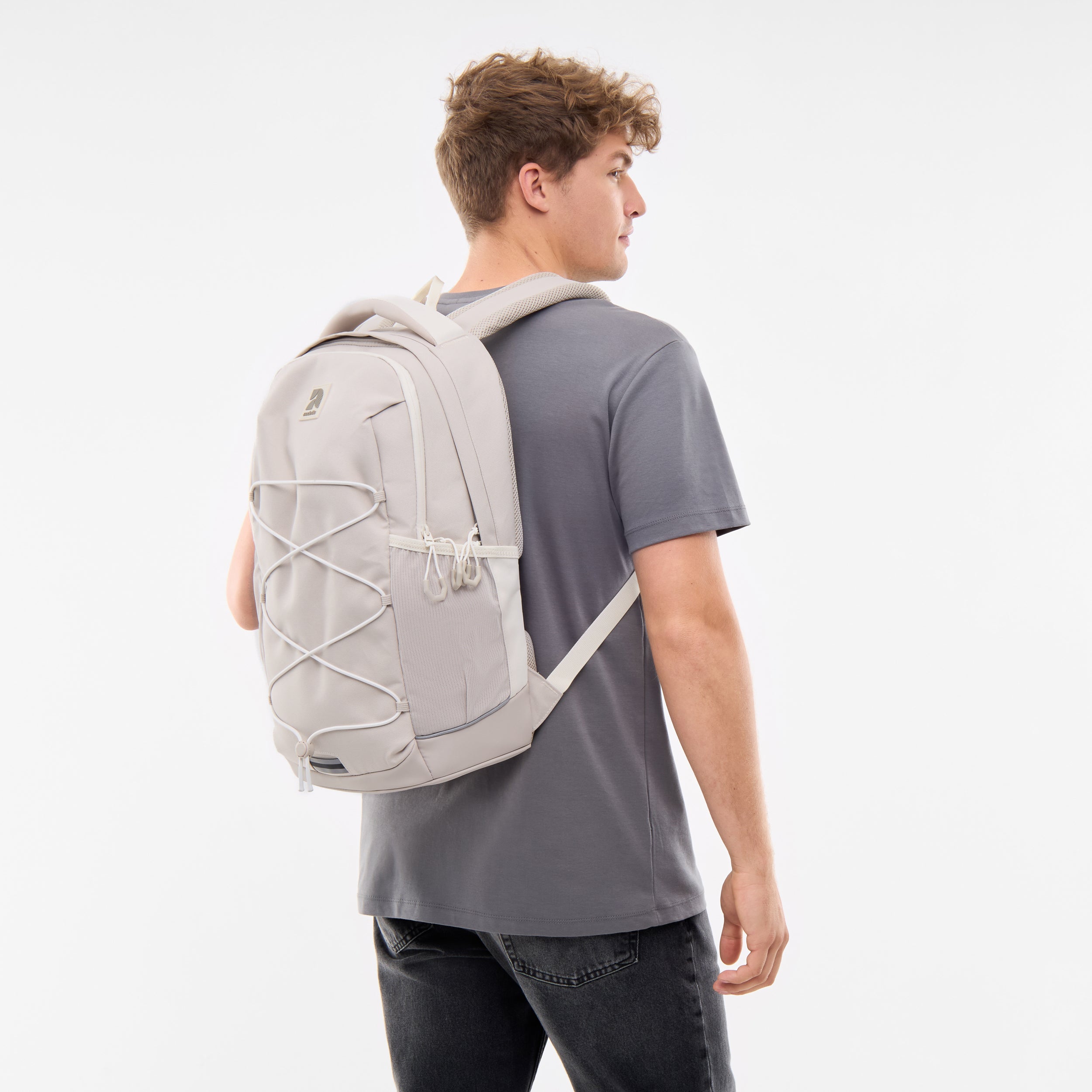 Junge trägt hellsandfarbenen Schulrucksack AERO mit elastichem Frontband und Seitentaschen