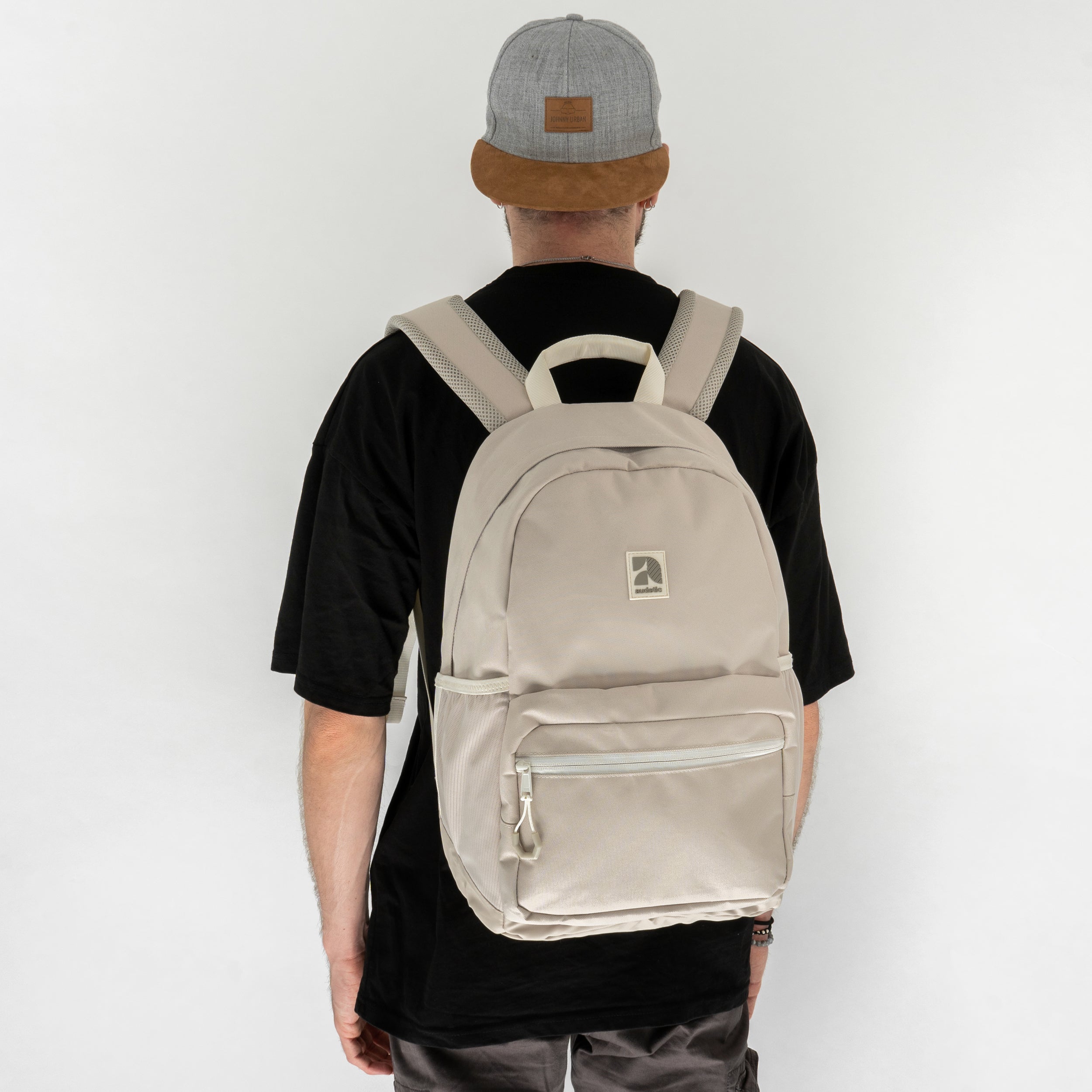 Schulrucksack FLEX beige getragen von Person mit schwarzem T-Shirt und grauer Kappe von hinten