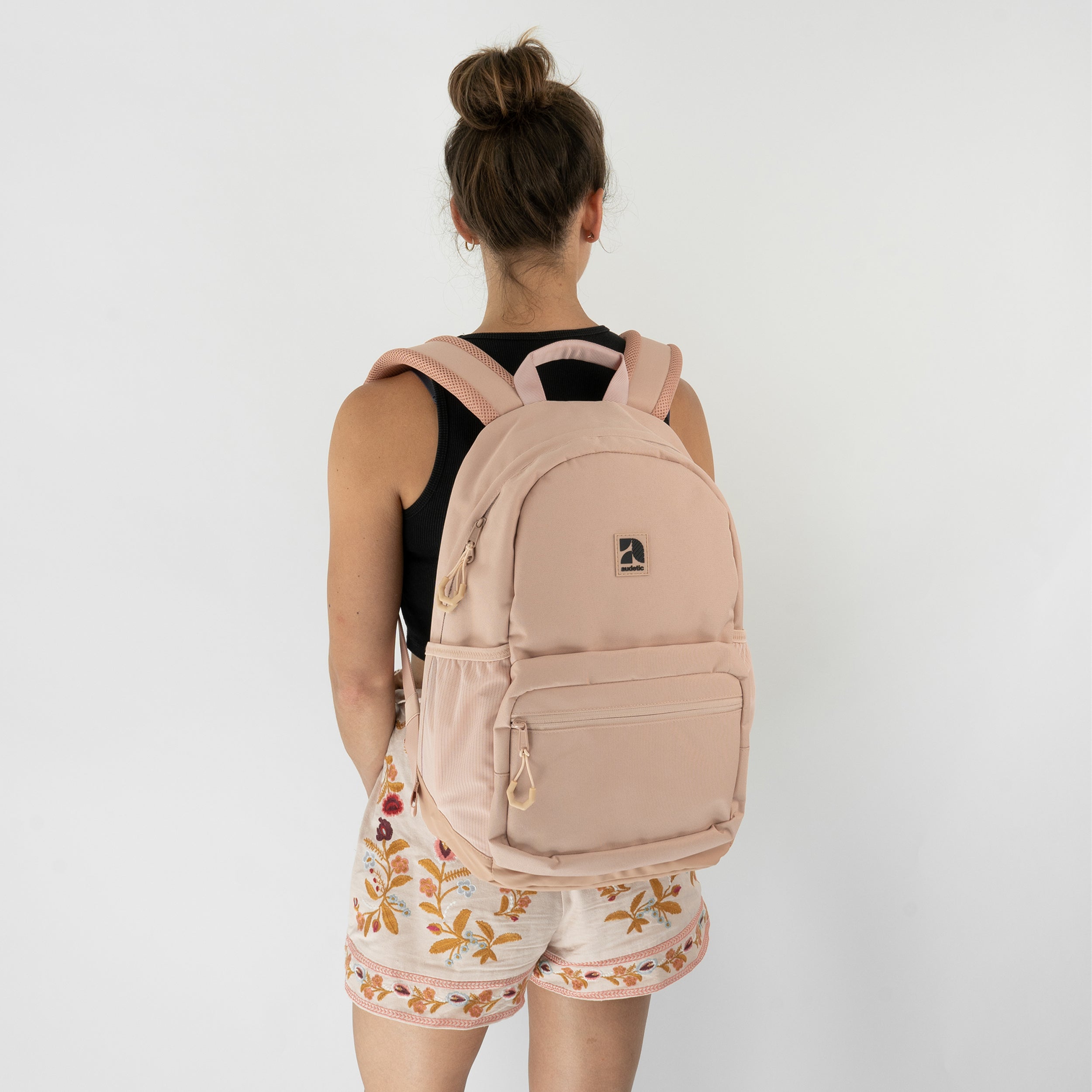 Teenager-Mädchen von hinten mit rosa Schulrucksack FLEX von audetic und schwarzem ärmellosem Oberteil