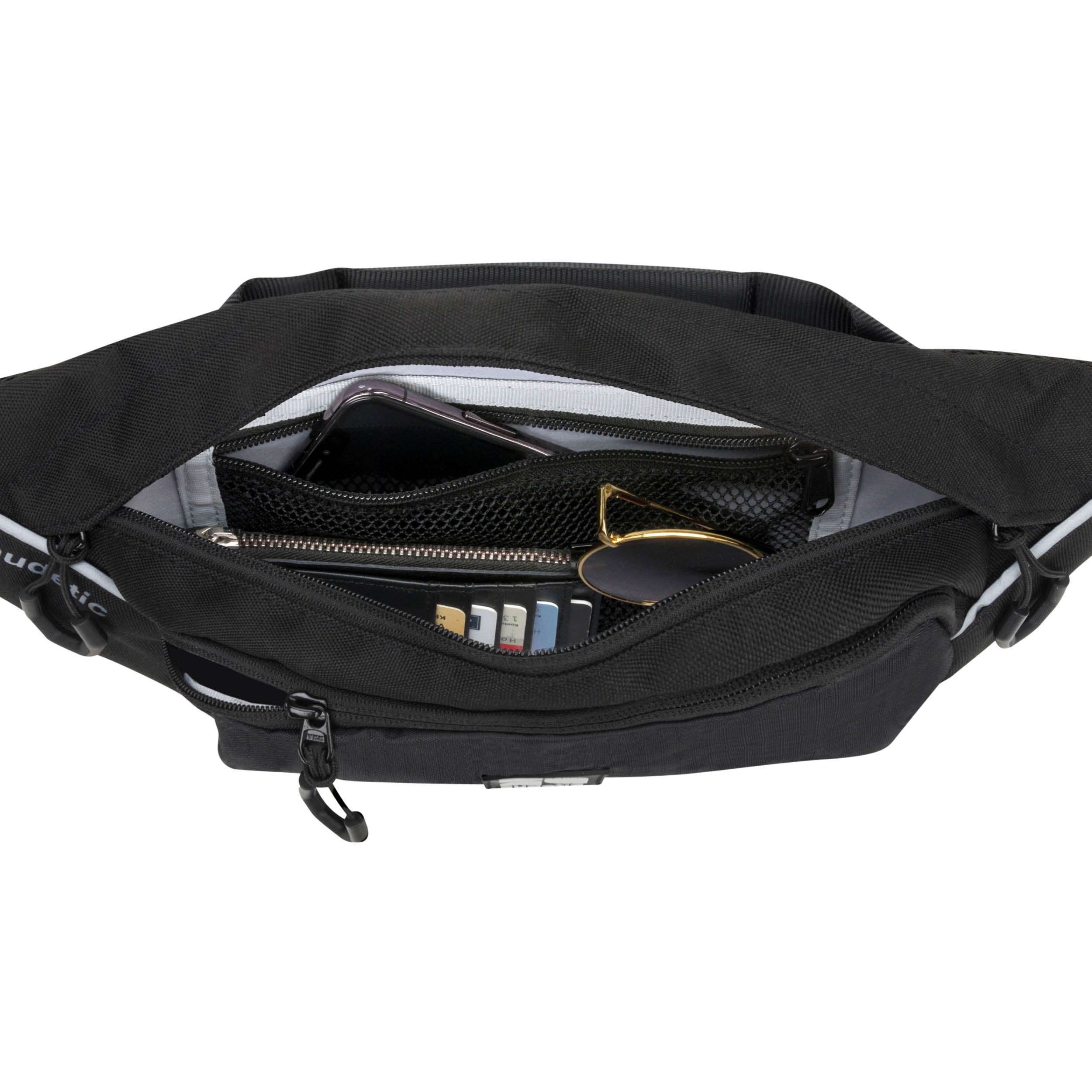 Schwarze Bauchtasche DRIP von Audetic mit offenem Hauptfach und Organisatoren, Smartphone, Geldbörse und Sonnenbrille sichtbar